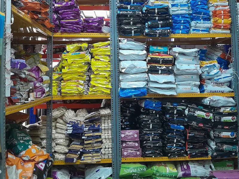 Shelves stocked with various bags of pet food in a warehouse setting