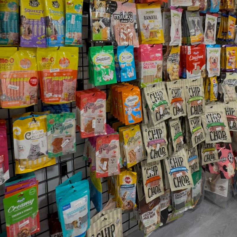 Display of various pet treat packages on a wall