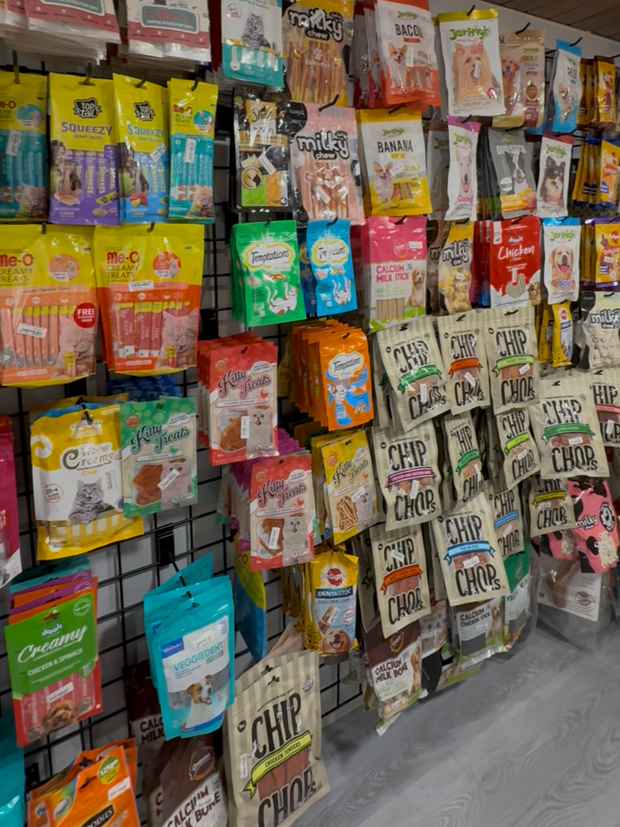 Display of various pet treat packages on a wall